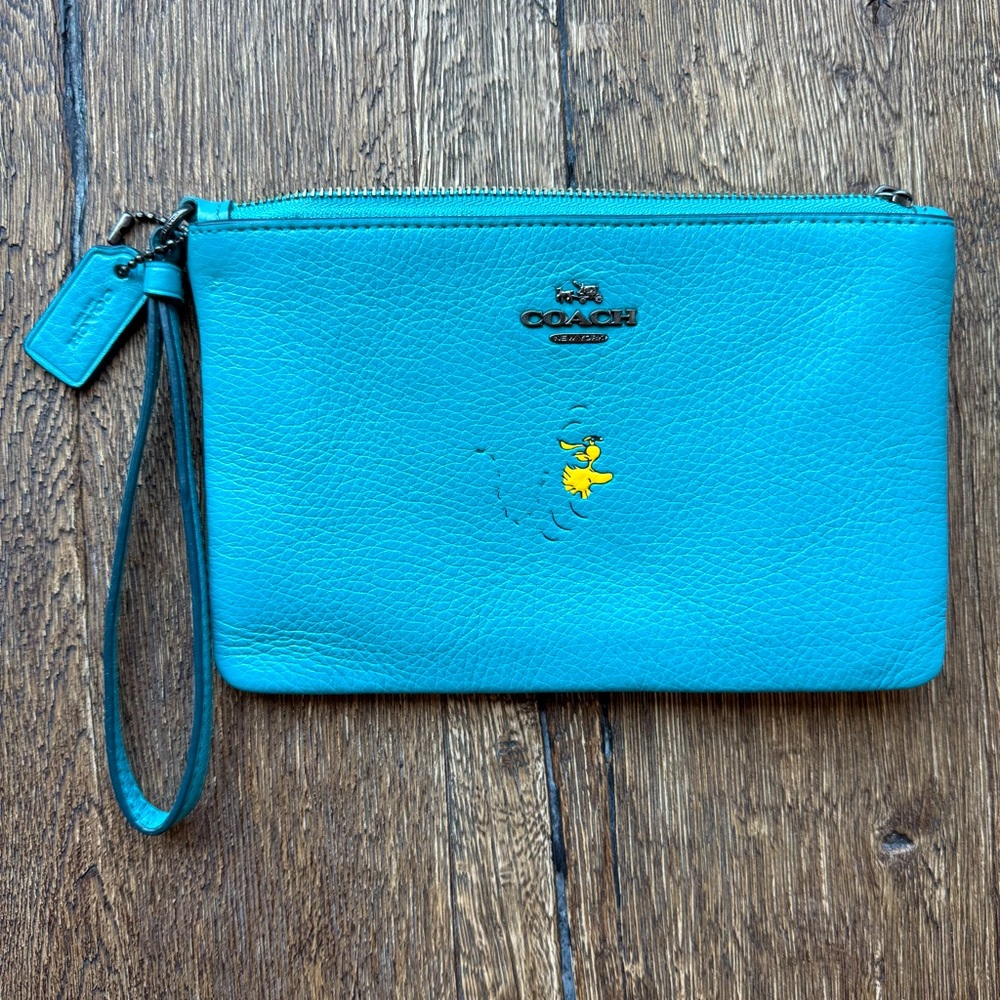 Coach x Peanuts Corner Zip Wristlet with Snoopy’s Woodstock motif